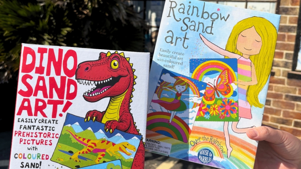 2 Sand Art boxes for the workshop, one with a dinosaur design, and one with a rainbow design.